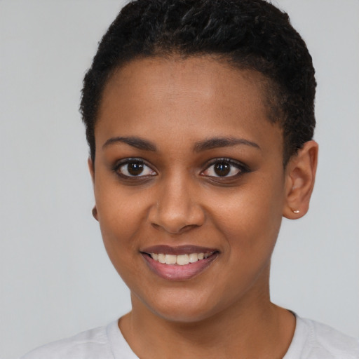 Joyful black young-adult female with short  black hair and brown eyes