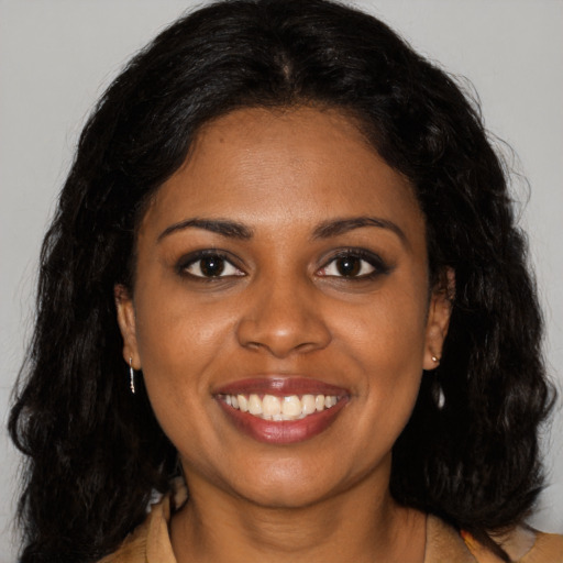 Joyful black young-adult female with long  brown hair and brown eyes