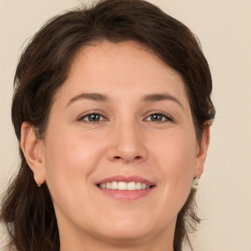 Joyful white young-adult female with long  brown hair and brown eyes