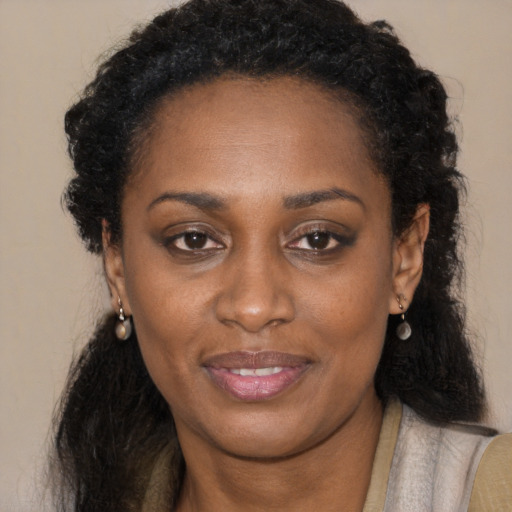Joyful black young-adult female with long  brown hair and brown eyes