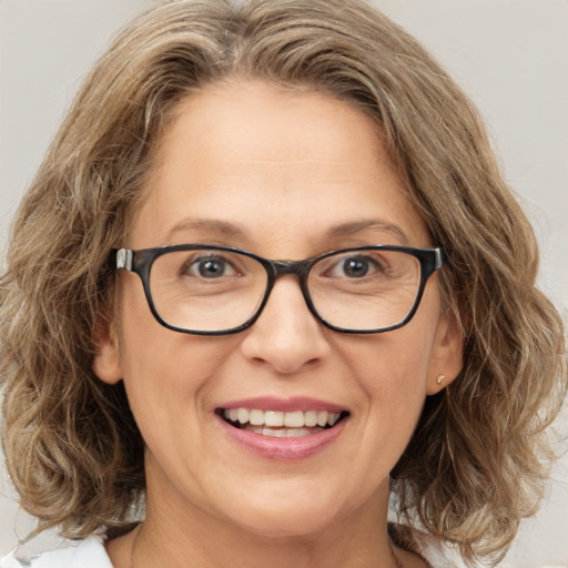 Joyful white adult female with medium  brown hair and blue eyes