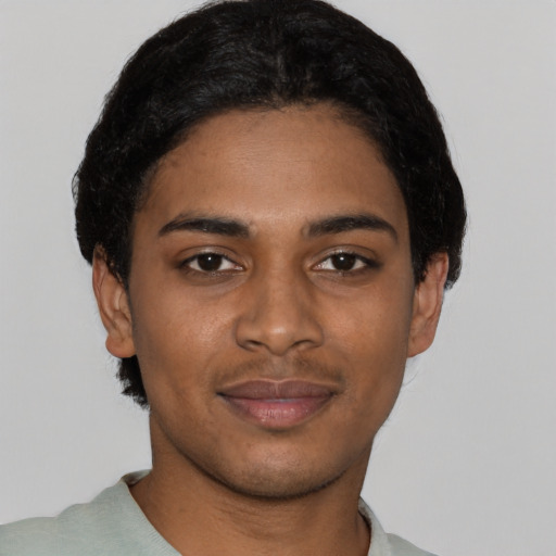 Joyful black young-adult male with short  black hair and brown eyes