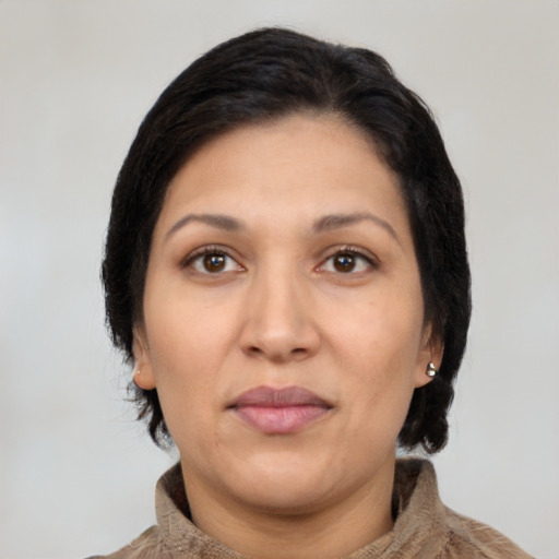 Joyful latino adult female with medium  brown hair and brown eyes