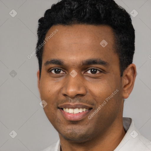 Joyful black young-adult male with short  black hair and brown eyes