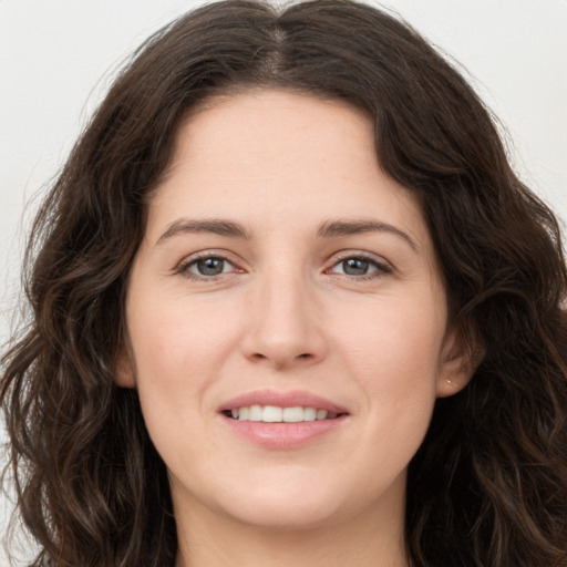 Joyful white young-adult female with long  brown hair and brown eyes