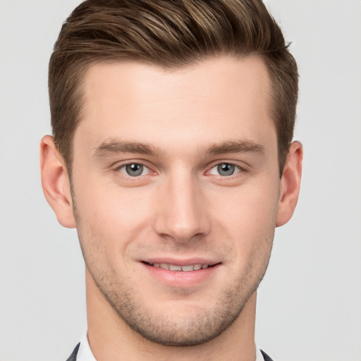 Joyful white young-adult male with short  brown hair and grey eyes