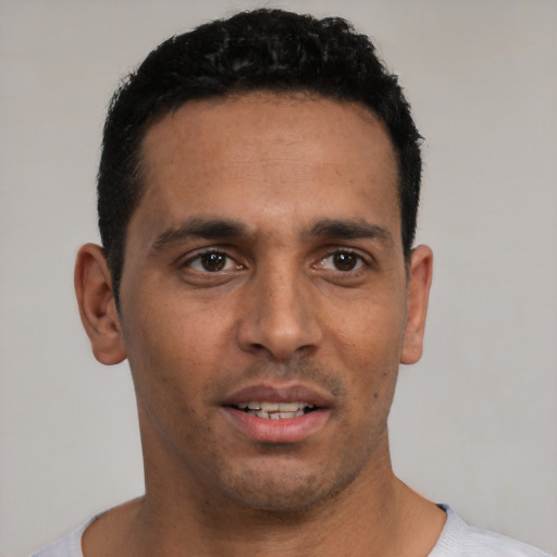 Joyful white young-adult male with short  black hair and brown eyes