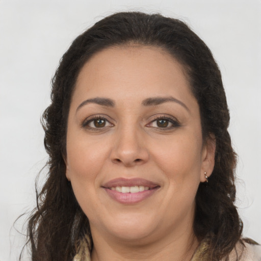 Joyful latino adult female with long  brown hair and brown eyes