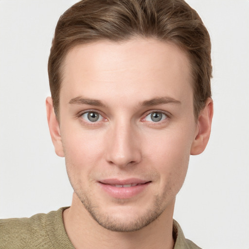 Joyful white young-adult male with short  brown hair and grey eyes