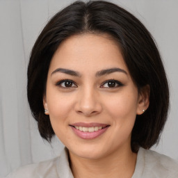 Joyful latino young-adult female with medium  brown hair and brown eyes