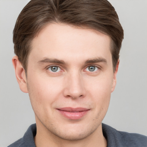 Joyful white young-adult male with short  brown hair and grey eyes