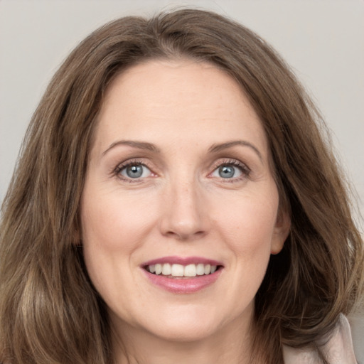 Joyful white young-adult female with long  brown hair and grey eyes