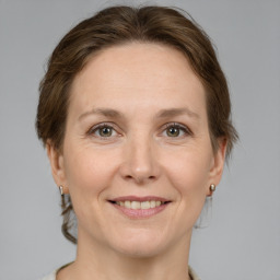 Joyful white adult female with medium  brown hair and grey eyes