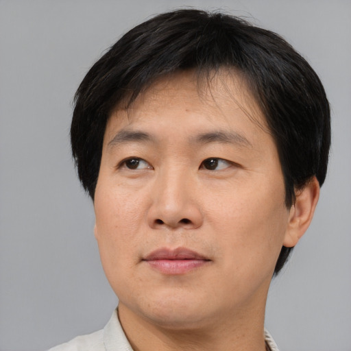 Joyful asian adult male with short  black hair and brown eyes