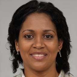 Joyful black adult female with medium  brown hair and brown eyes