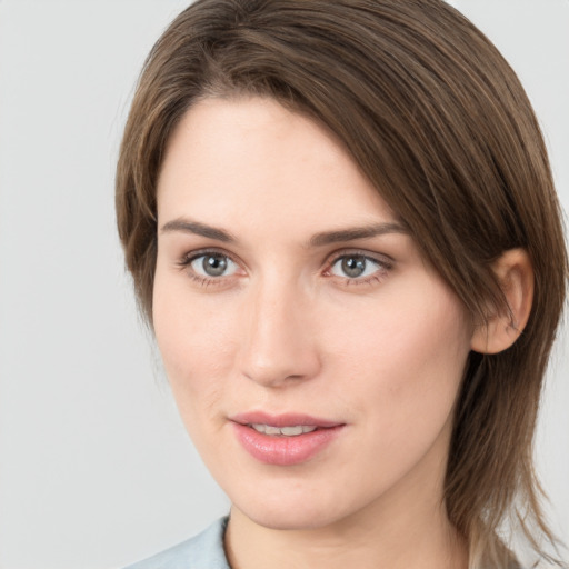 Joyful white young-adult female with medium  brown hair and grey eyes