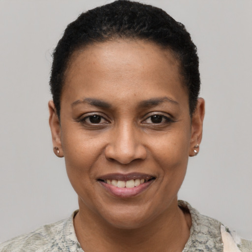 Joyful black young-adult female with short  black hair and brown eyes
