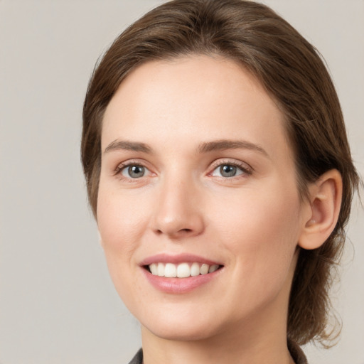 Joyful white young-adult female with medium  brown hair and grey eyes