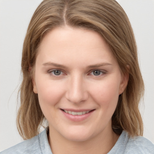 Joyful white young-adult female with medium  brown hair and grey eyes