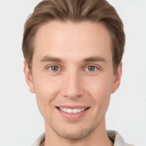 Joyful white young-adult male with short  brown hair and grey eyes