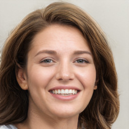 Joyful white young-adult female with long  brown hair and blue eyes