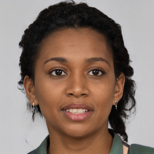 Joyful black young-adult female with medium  black hair and brown eyes