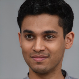 Joyful latino young-adult male with short  brown hair and brown eyes