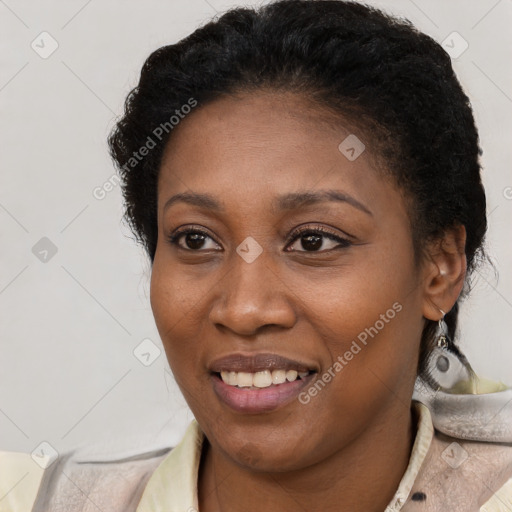 Joyful black young-adult female with short  brown hair and brown eyes