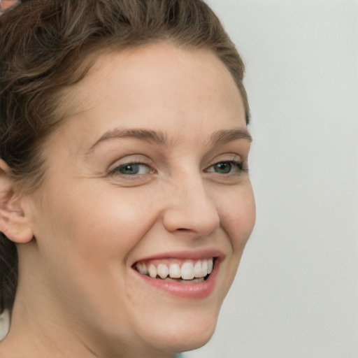 Joyful white young-adult female with medium  brown hair and green eyes