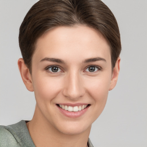 Joyful white young-adult female with short  brown hair and grey eyes