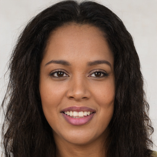 Joyful black young-adult female with long  brown hair and brown eyes