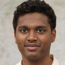 Joyful black young-adult male with short  brown hair and brown eyes