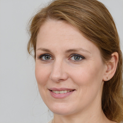 Joyful white adult female with medium  brown hair and blue eyes