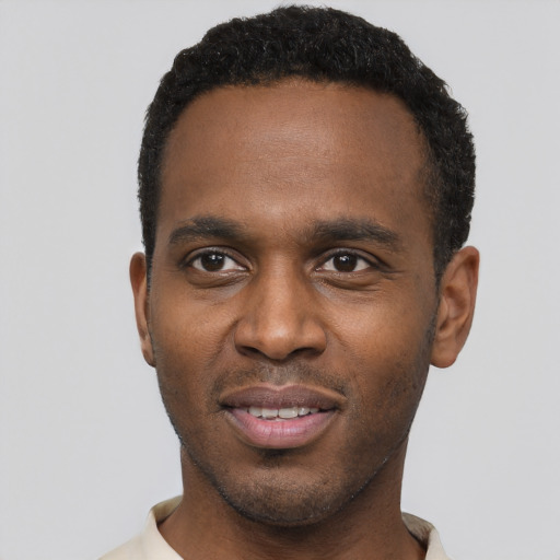 Joyful black young-adult male with short  black hair and brown eyes