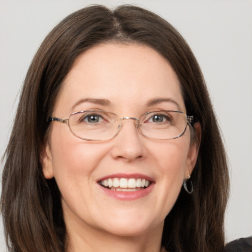 Joyful white adult female with long  brown hair and grey eyes