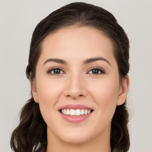 Joyful white young-adult female with long  brown hair and brown eyes