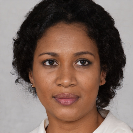 Joyful black adult female with medium  black hair and brown eyes