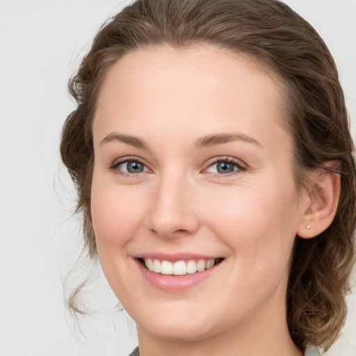 Joyful white young-adult female with medium  brown hair and green eyes