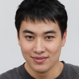 Joyful asian young-adult male with short  brown hair and brown eyes