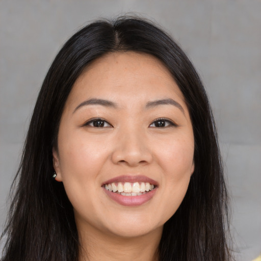 Joyful asian young-adult female with long  brown hair and brown eyes