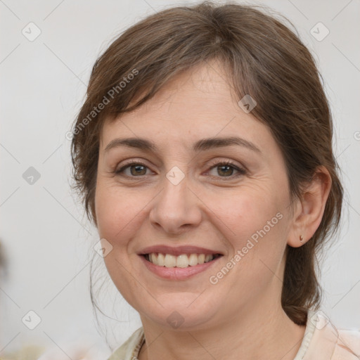 Joyful white adult female with medium  brown hair and grey eyes