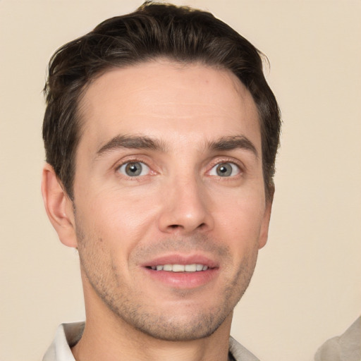 Joyful white young-adult male with short  brown hair and grey eyes