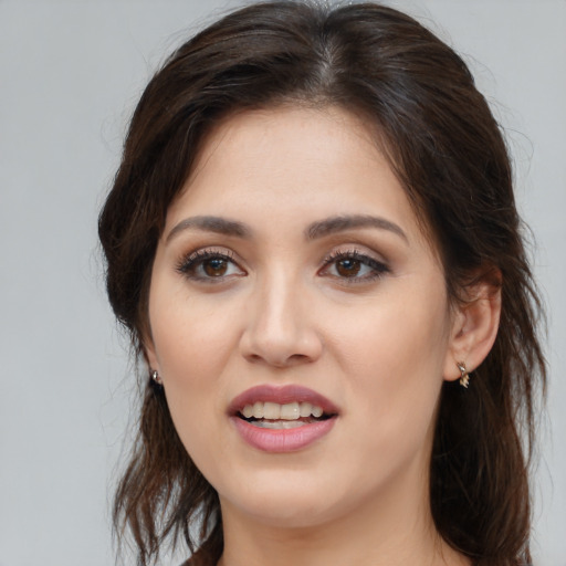 Joyful white young-adult female with long  brown hair and brown eyes