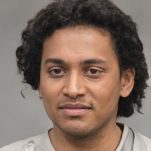 Joyful black young-adult male with short  black hair and brown eyes