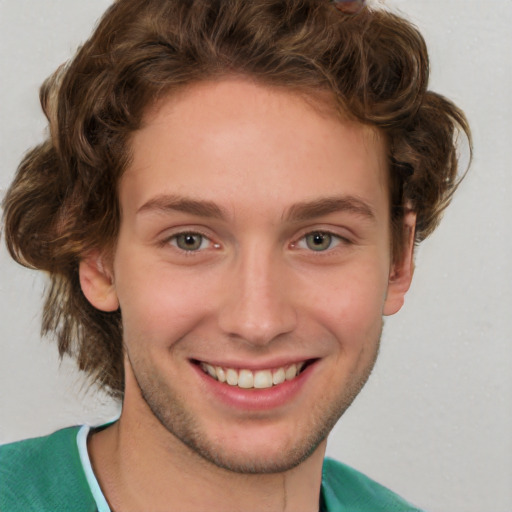 Joyful white young-adult male with short  brown hair and green eyes