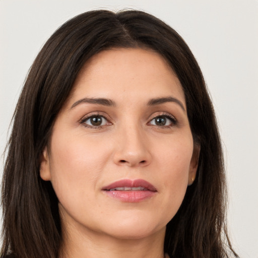 Joyful white young-adult female with long  brown hair and brown eyes