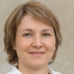 Joyful white adult female with medium  brown hair and grey eyes