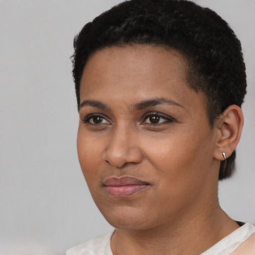 Joyful black young-adult female with short  black hair and brown eyes