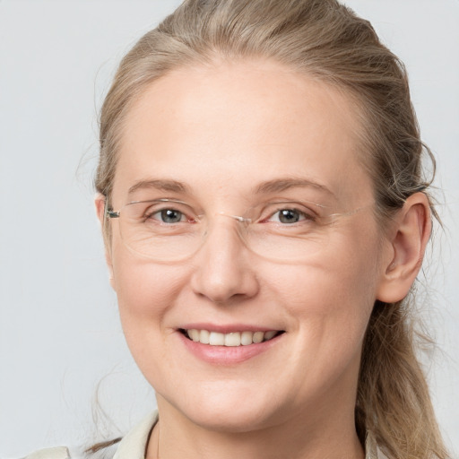 Joyful white adult female with long  brown hair and grey eyes