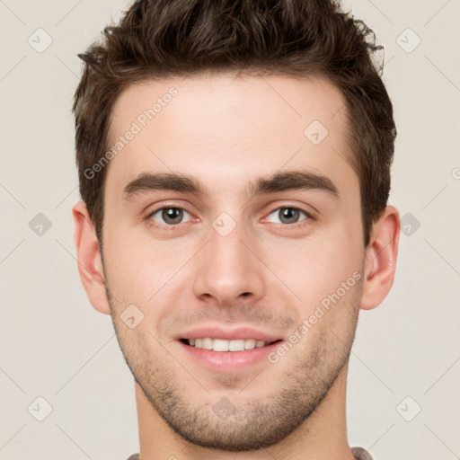 Joyful white young-adult male with short  brown hair and grey eyes